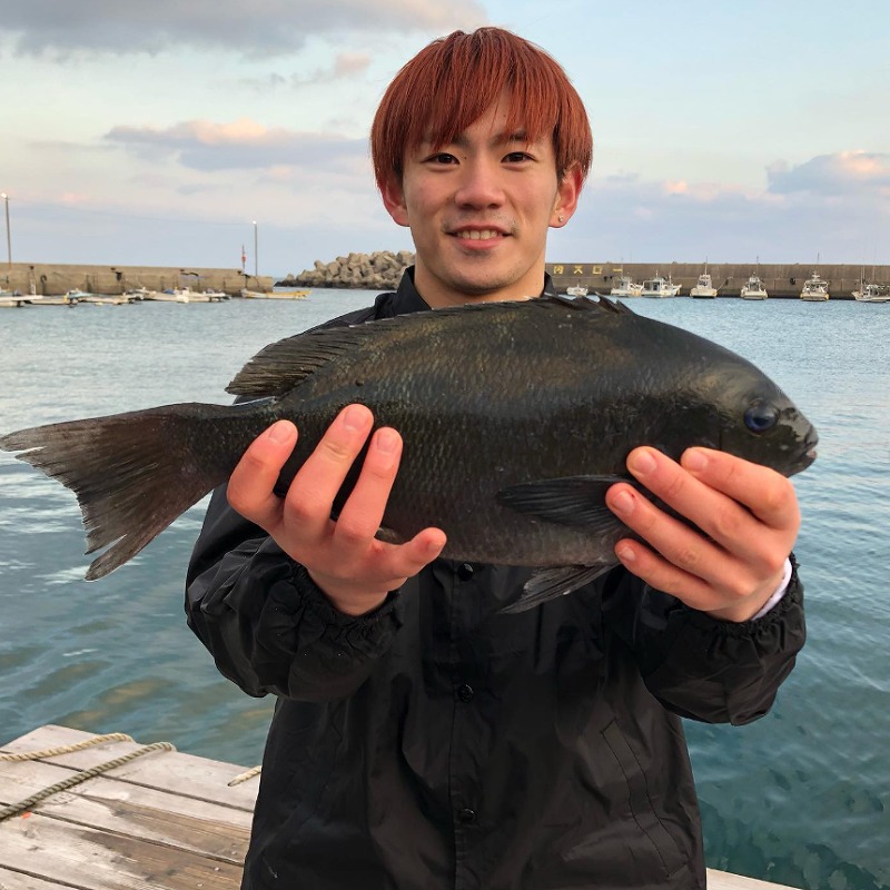 海辺で魚を持つ浦川翔平の画像