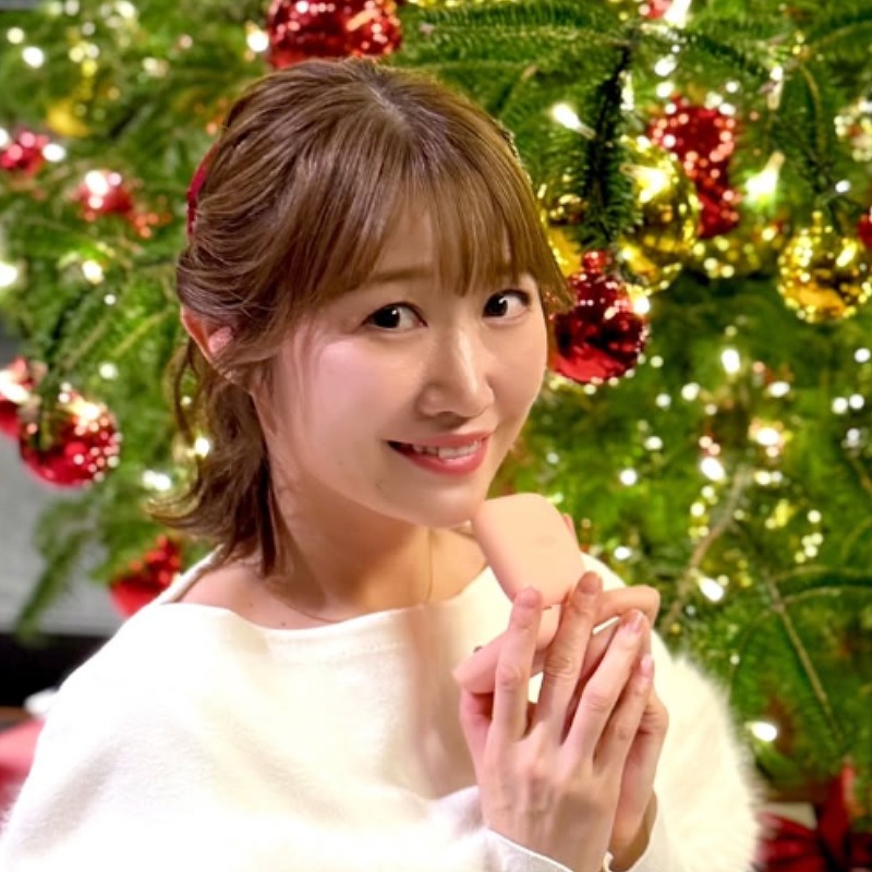 浦野一美がクリスマスツリーの前で微笑む画像