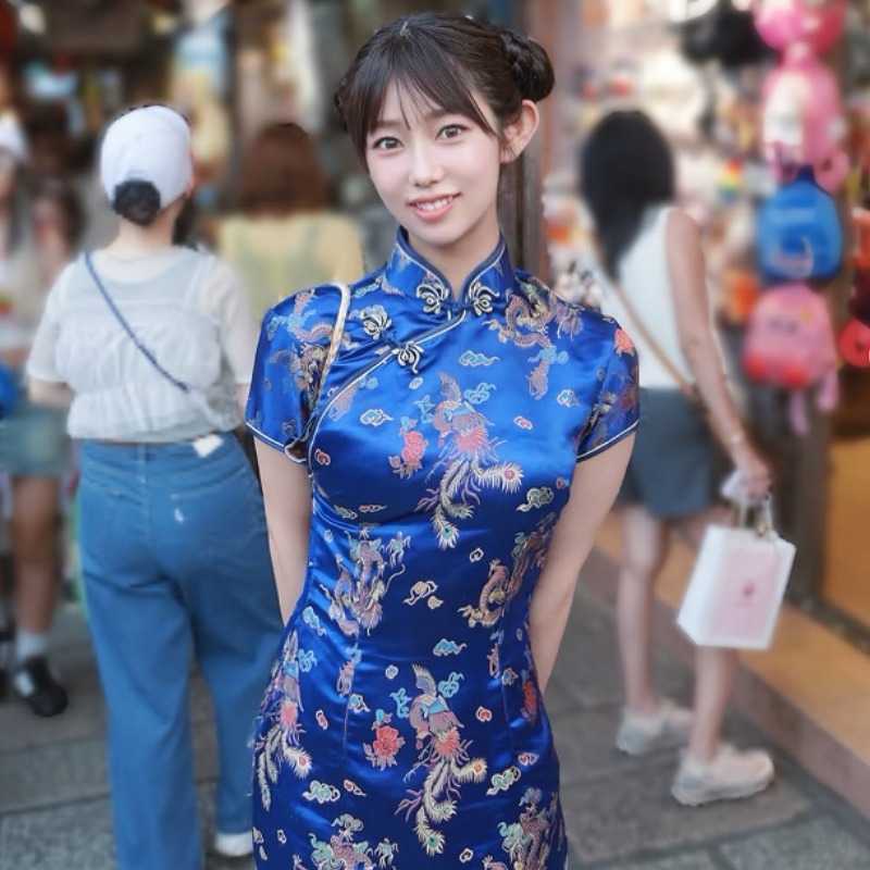 堀江聖夏が青いチャイナドレスを着て街中に立つ画像