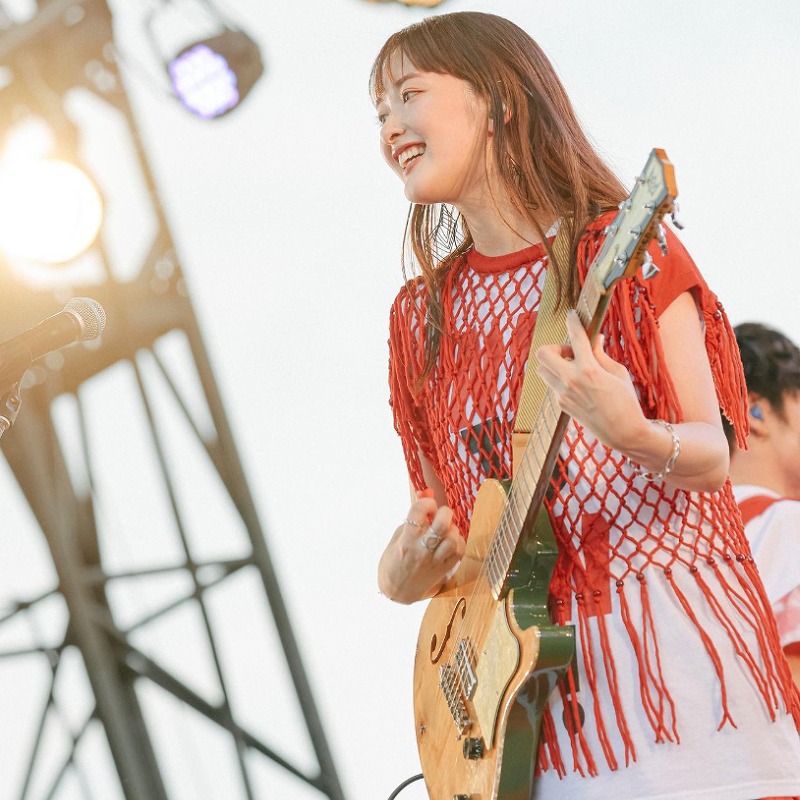 長屋春子がステージ上でギターを弾いている画像