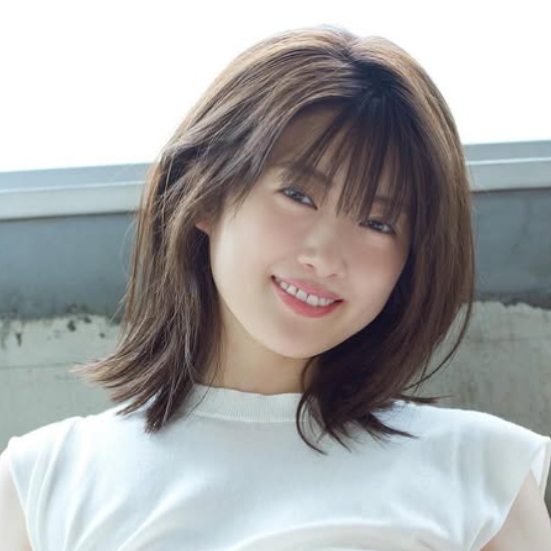樋口日奈が白い服を着て座り微笑む画像
