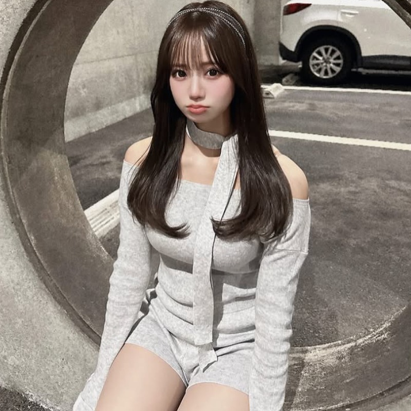 和田海佑が薄いグレーの服を着て駐車場の壁に座る画像
