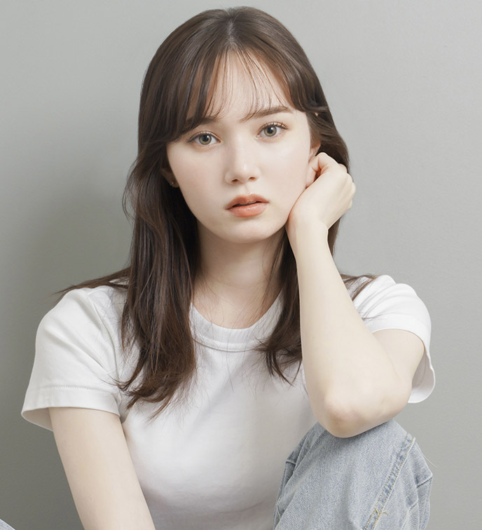 マーシュ彩が白いシャツにデニム姿で座る画像