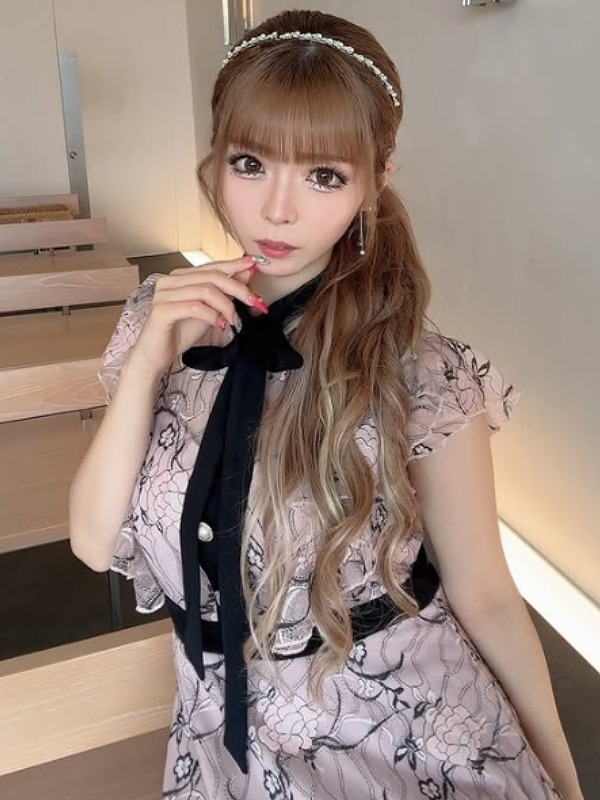ゆいちゃみ(ゆい小池)が薄ピンクの服に黒い大きなリボンを付けている画像