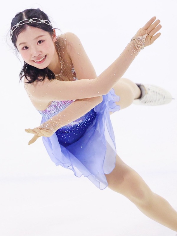 青紫のコスチューム姿でフィギュアスケートをする中井亜美選手の画像