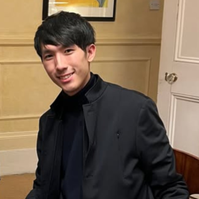 エリック・ルーが黒い服を着て椅子に腰かけている画像