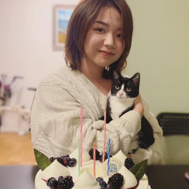 ワン・ズィトンが誕生日にケーキの前で猫を抱く画像