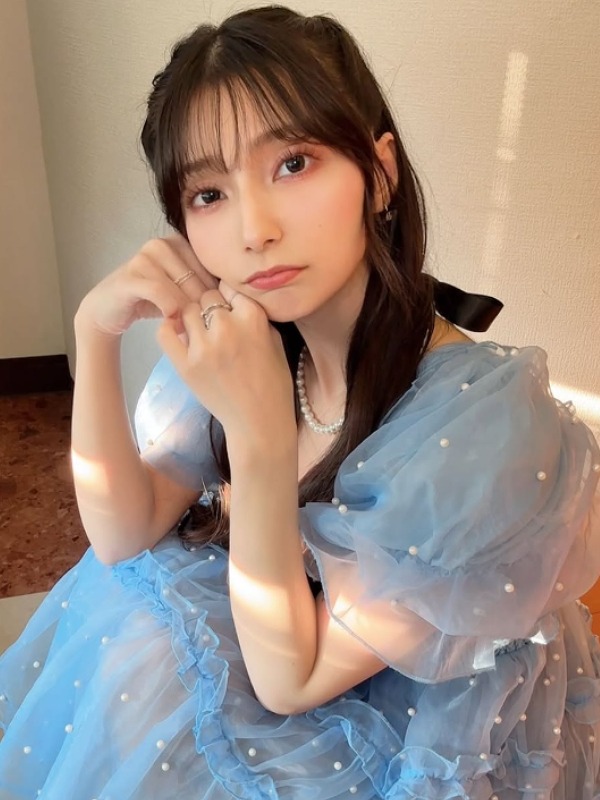 高野麻里佳が青いドレスを着てオレンジ色のソファに座っている画像