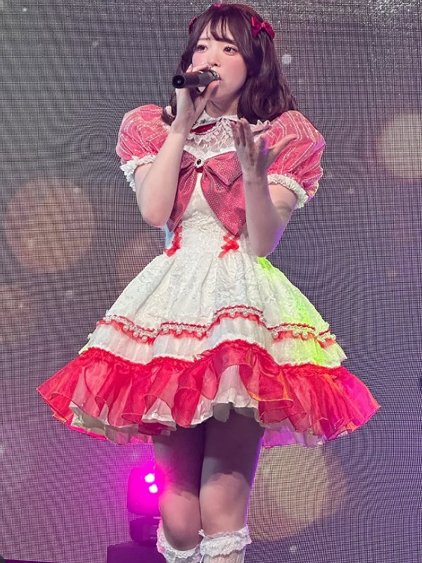 塩見きらがアイドルのステージ衣装を着て歌っている画像