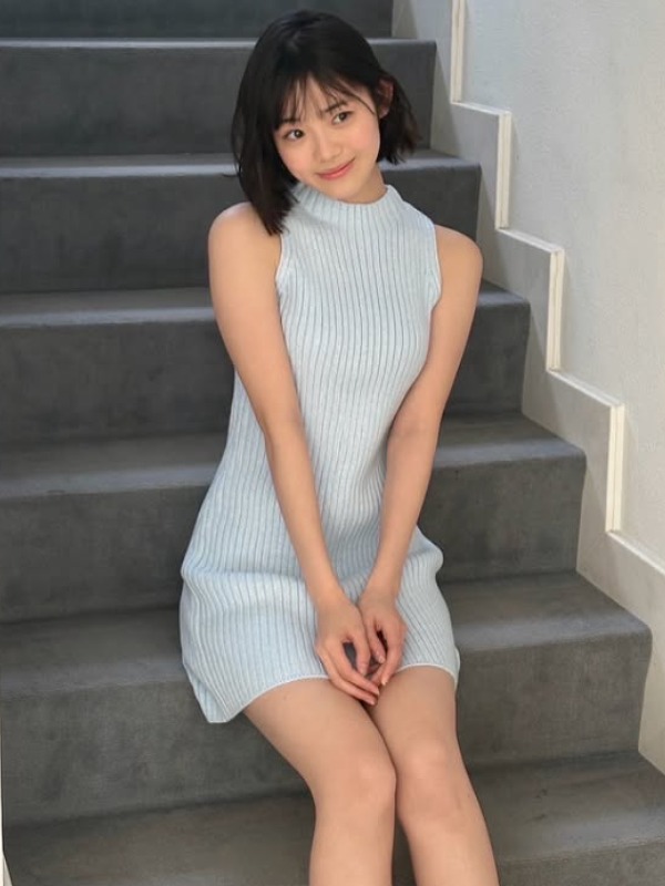 空色のニットワンピ姿で階段に座る志田こはくの画像