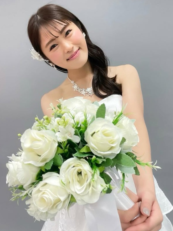 渋谷凪咲が白いドレスを着て花束を差し出す画像