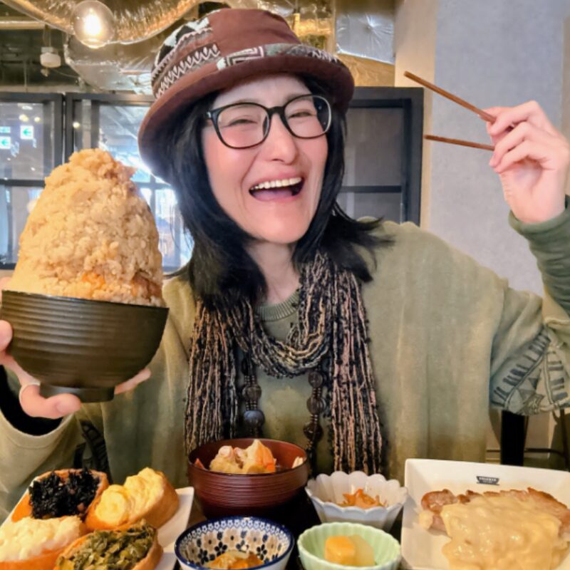 山盛りのチャーハンを持つアンジェラ佐藤の画像