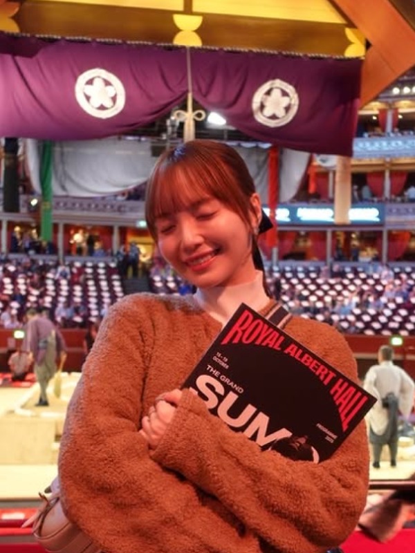 山根千佳が相撲のロンドン公演の土俵の前に立つ画像