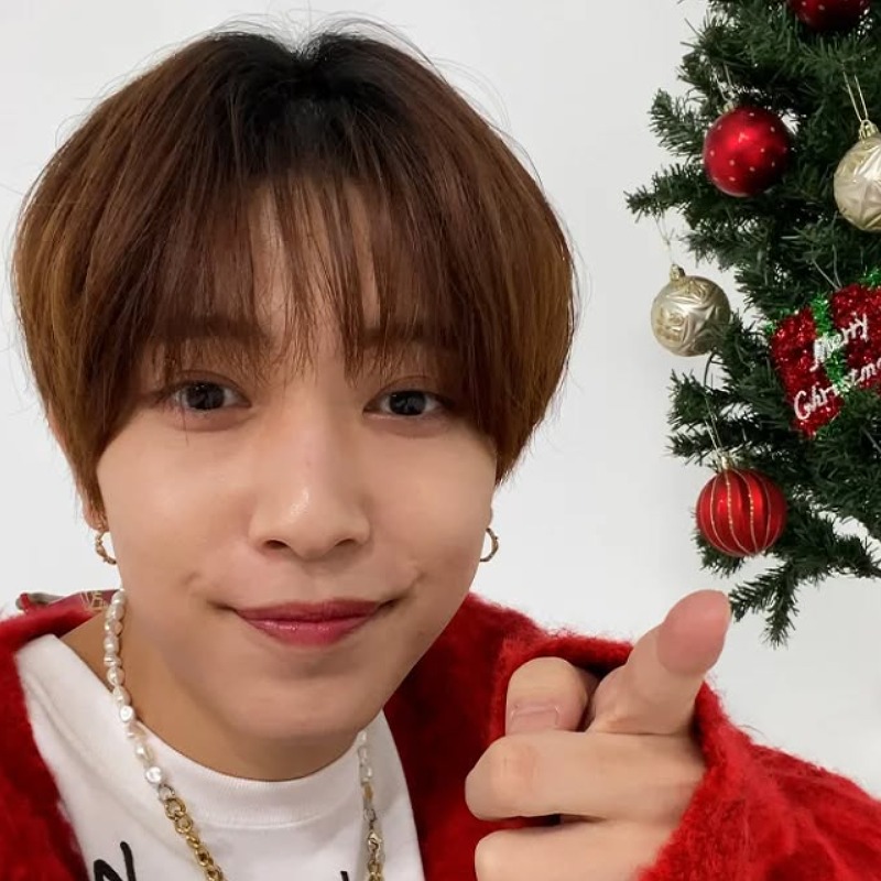 中村嶺亜がクリスマスツリーの横で指を指す仕草をしている画像