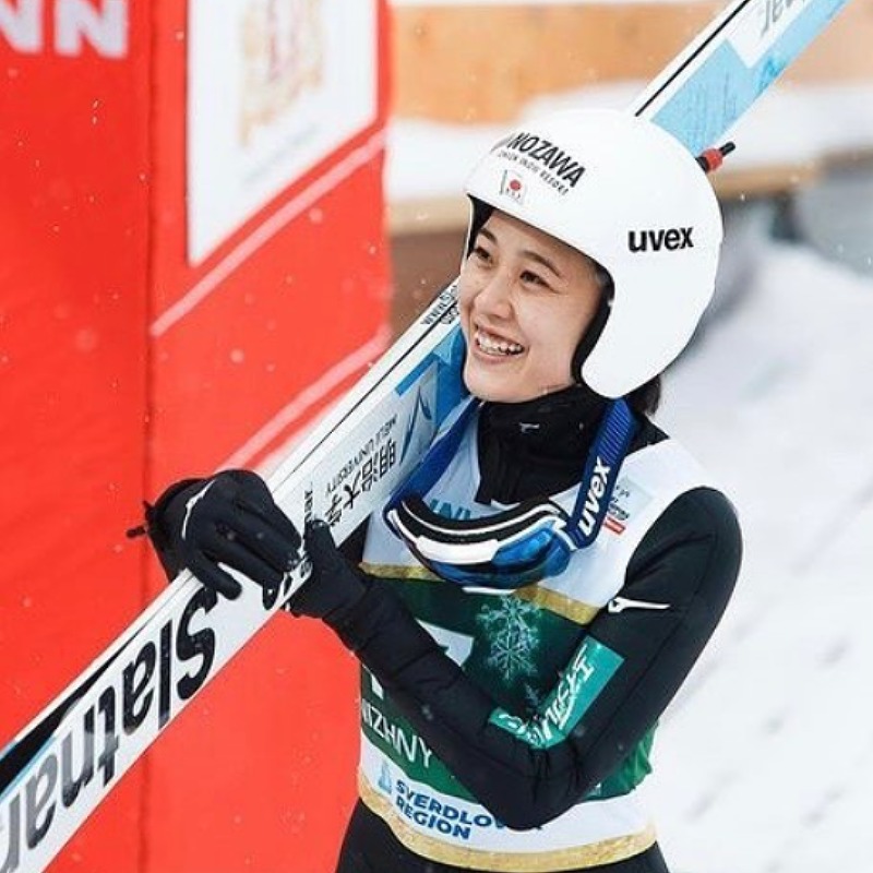 丸山希がスキーを肩に担ぎ笑顔の画像
