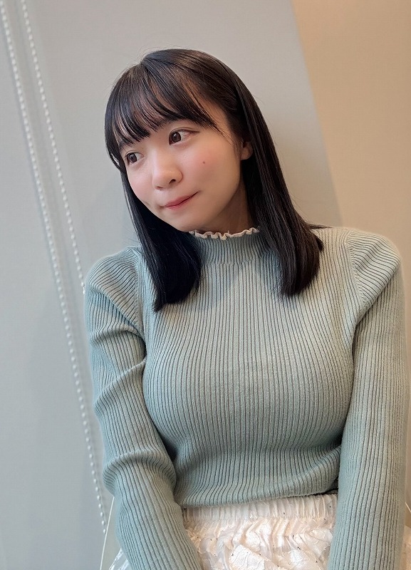 椿野ゆうこが薄い緑色のニットを着ている画像