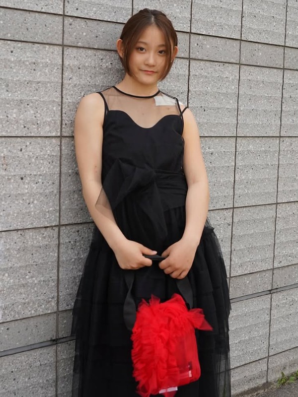 清水さらが黒いドレスを着て赤いバッグを持っている画像