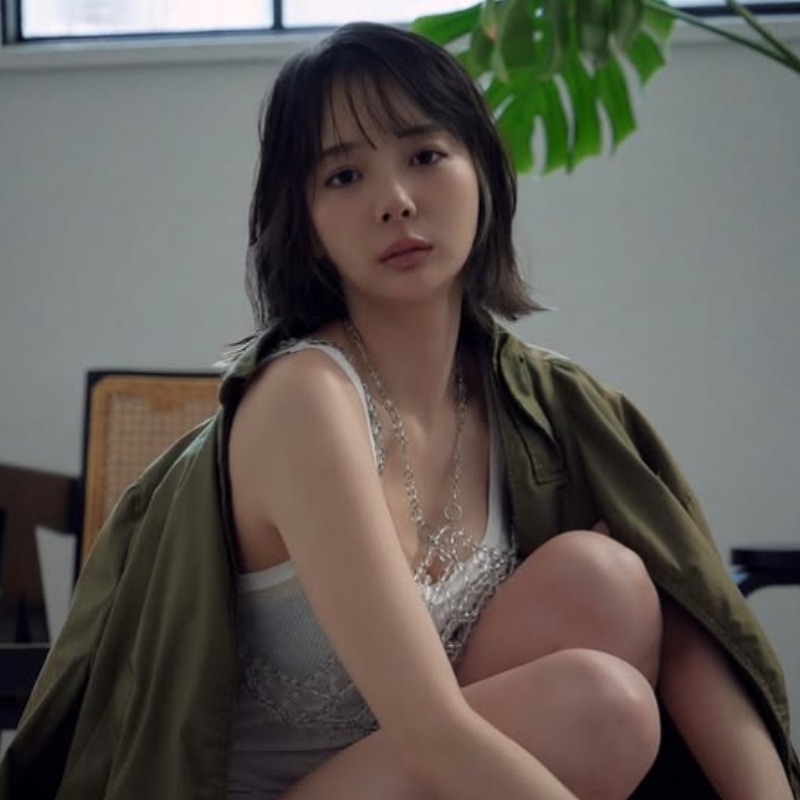 岡田紗佳がカーキ色のコートを羽織ってしゃがむ画像