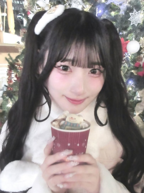齋藤樹愛羅が紙コップの飲み物を持ちクリスマスツリーの前にいる画像