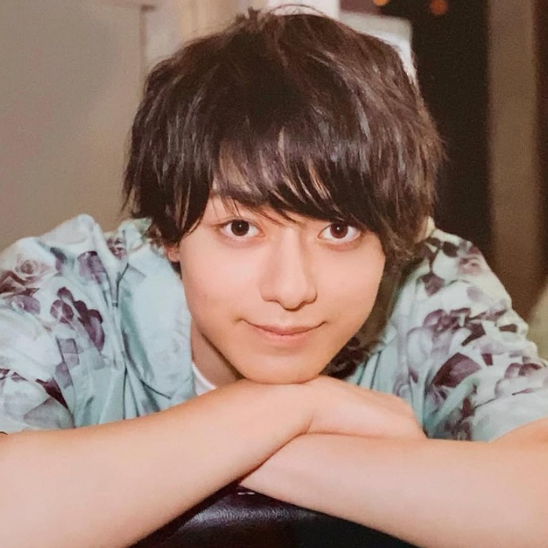 作間龍斗が腕を組み手に顎を乗せている画像