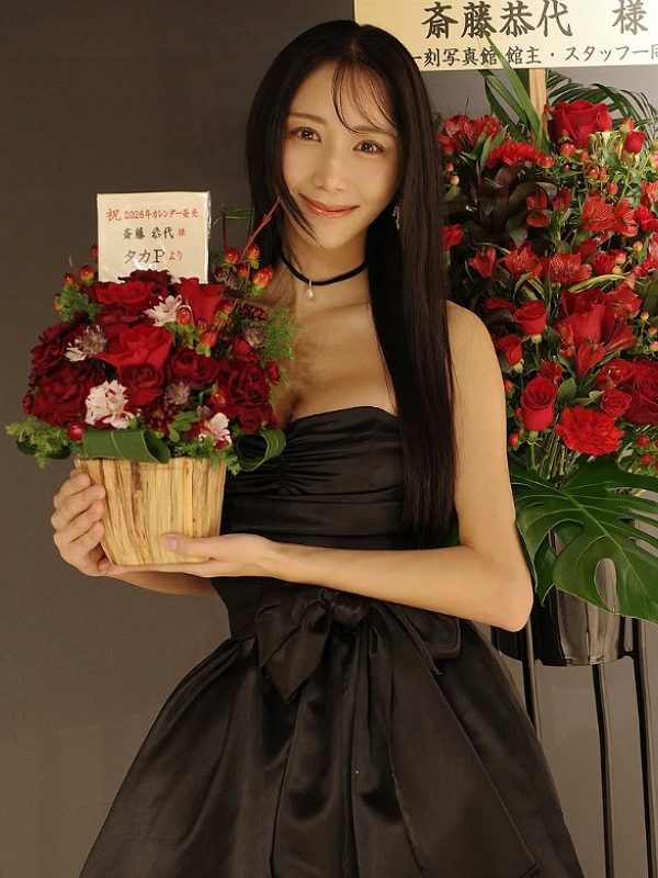 斎藤恭代が黒いドレスで赤いバラの前に立つ画像