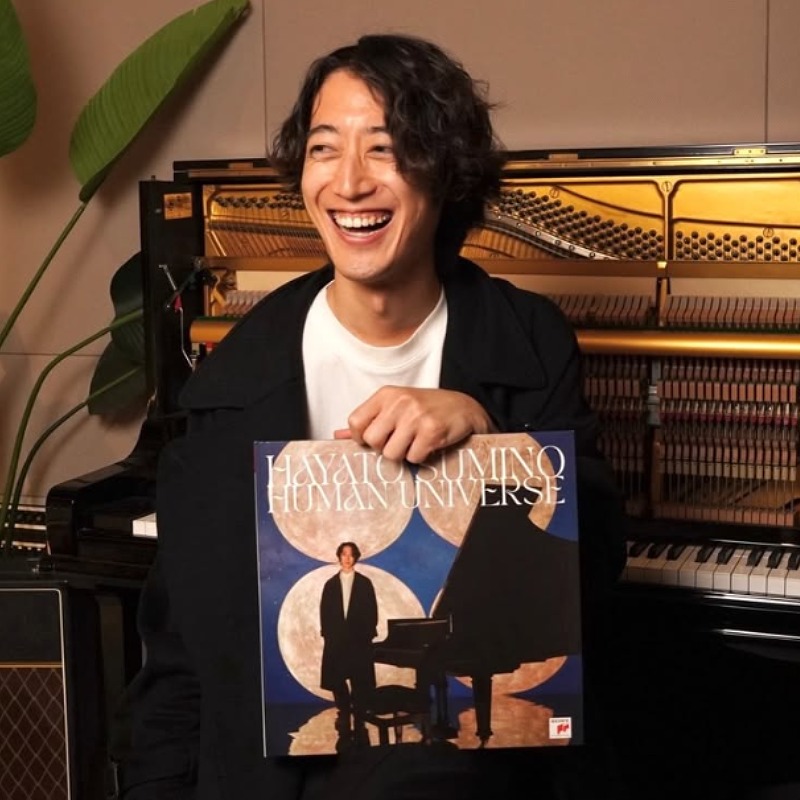 角野隼斗がピアノの前に座りレコードを持ち笑顔の画像