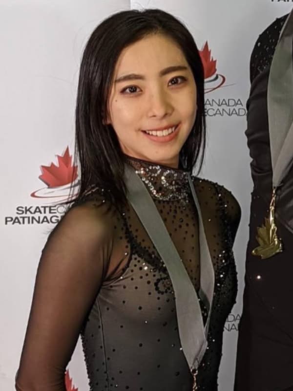 三浦璃来が黒いコスチューム姿で立つ画像