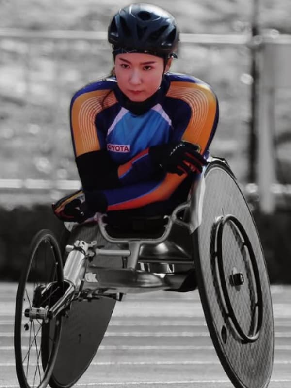 村岡桃佳が車いす陸上の競技をする画像