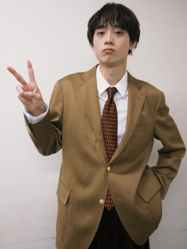 水沢林太郎の2025年11月の学園祭イベント時のオフショットです。きっちりしたジャケット姿と、少しお茶目なピースサインの対比が、まさに「184cmのギャップ」を感じさせます。