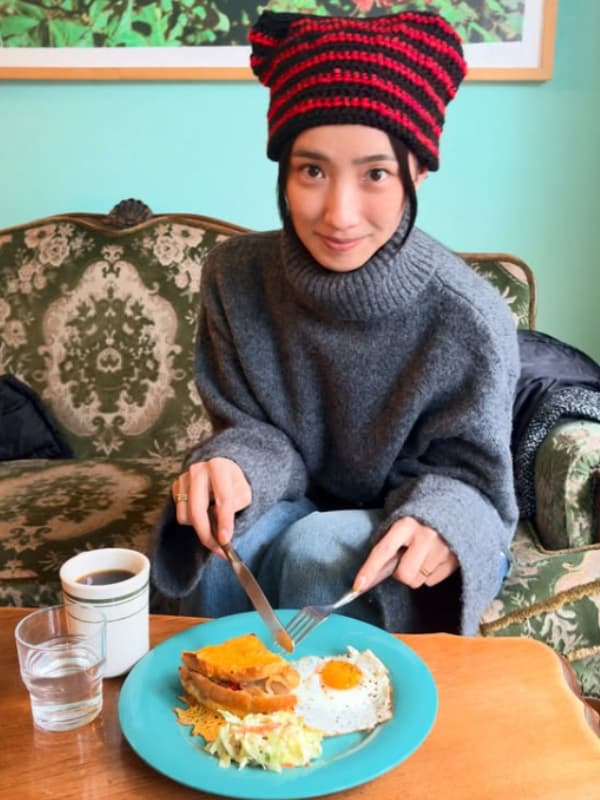 中田クルミがソファに座り食事をする画像