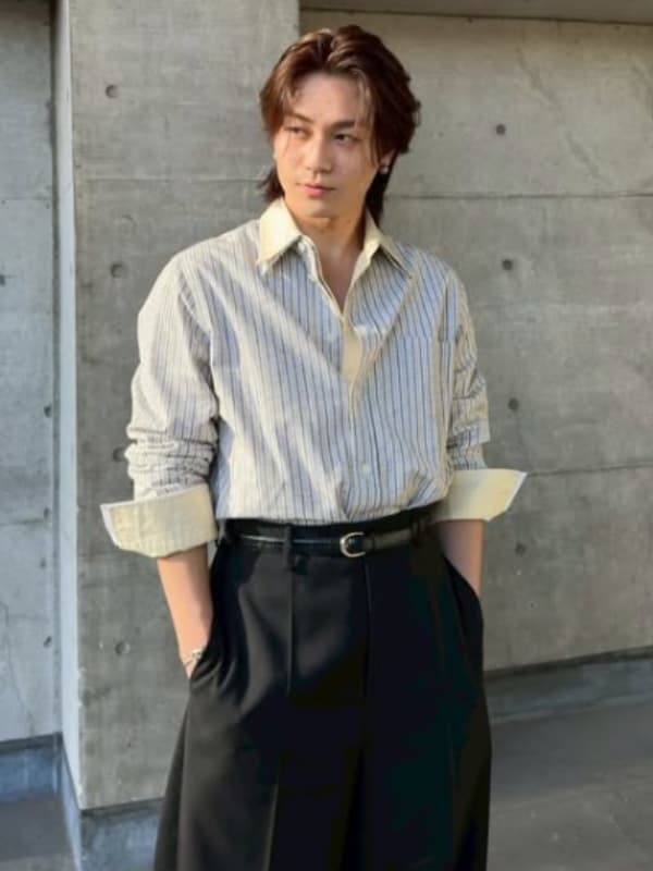 松田元太がストライプのシャツを着てコンクリート打ちっぱなしの壁の前に立つ画像