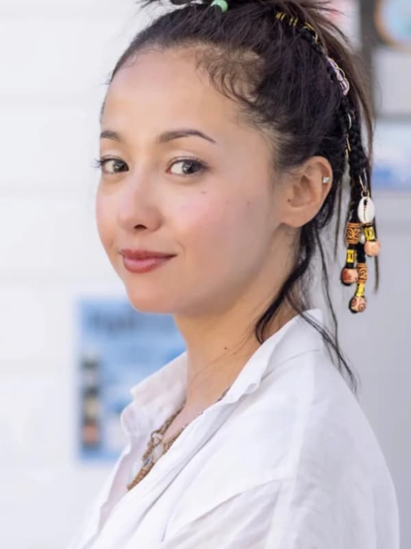 白シャツを着用し、髪をアップにまとめた沢尻エリカの横顔。髪に編み込まれたビーズやシェルなどのアクセサリーが特徴的な、ナチュラルで健康的な表情。