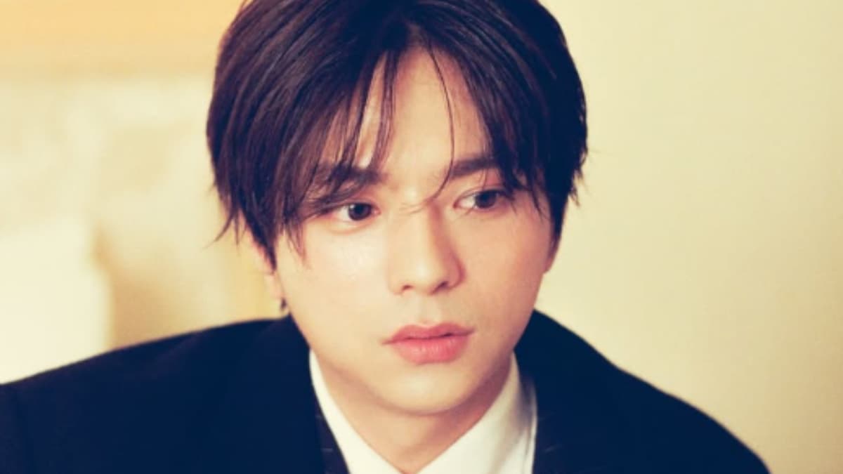 フォーマルな黒のスーツと白シャツを着用し、物憂げでアンニュイな表情を浮かべる佐藤勝利のクローズアップ写真。