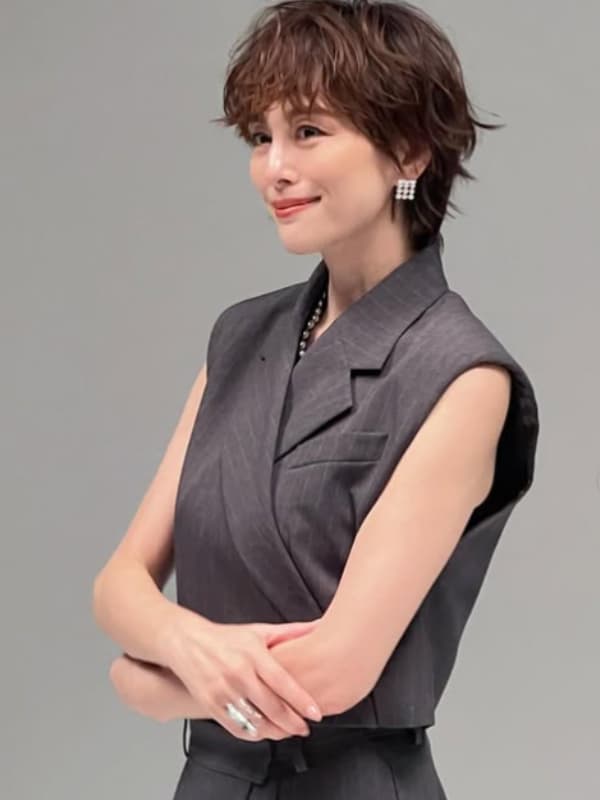 グレーのベストを纏い柔らかな笑みを浮かべる米倉涼子のポートレート
