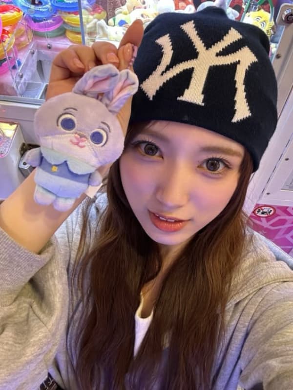 黒のニット帽を被りうさぎのぬいぐるみを手にする親しみやすい笑顔の矢吹奈子