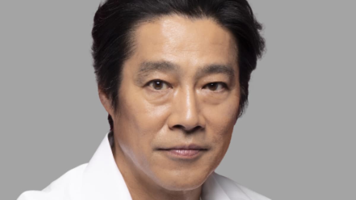 白いシャツを着用し、正面を向いて穏やかな表情を浮かべる俳優・堤真一のポートレート写真。背景はシンプルなライトグレー。