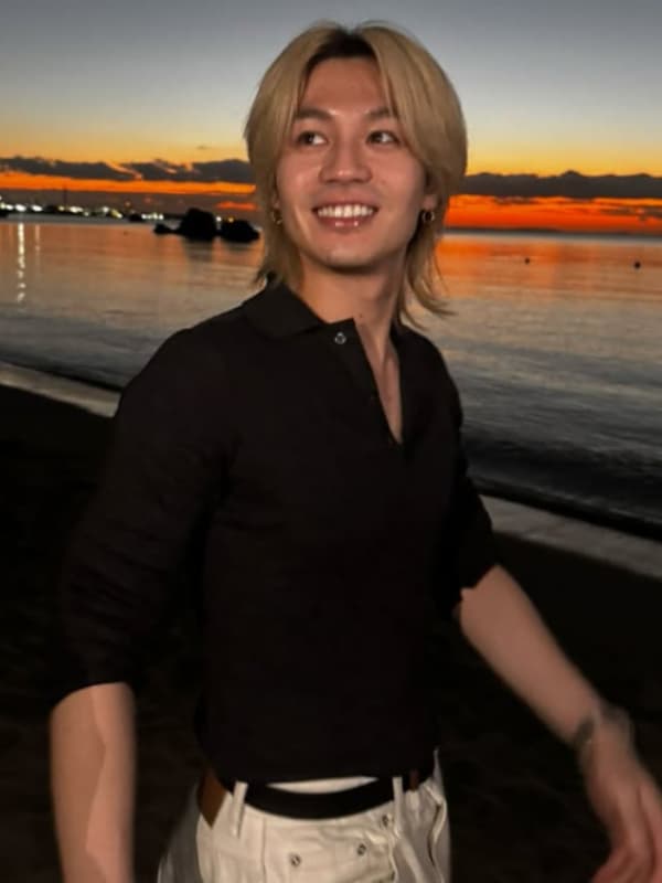 松田元太が夕焼けの海辺に立つ画像