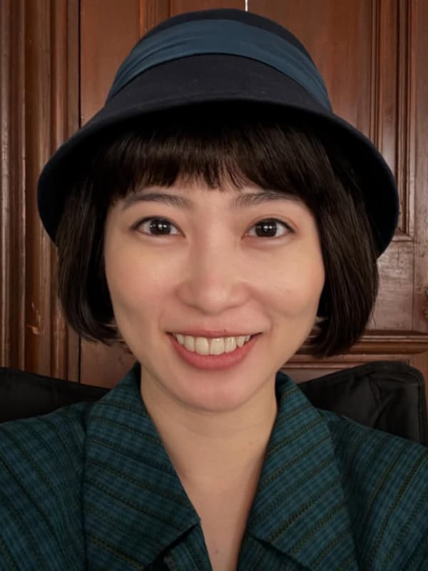 志田未来が緑色の服を着て黒い帽子を被っている画像