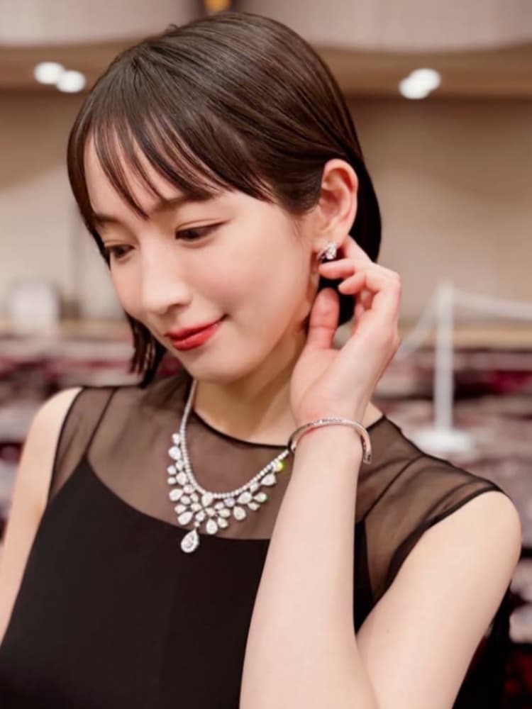 黒いドレスと高級なダイヤモンドジュエリーを着用した吉岡里帆。横を向いて微笑む姿。