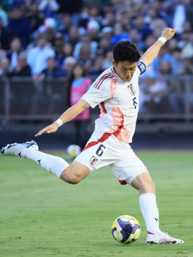 日本代表の白いアディダス製ユニフォーム(Y-3コラボモデル、背番号6)を着用し、ピッチで右足で力強くボールを蹴り出す遠藤航選手のプレー写真。