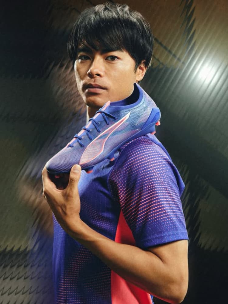PUMAの最新サッカースパイクを手に持ち、ブランドのビジュアルモデルを務める三笘薫選手。