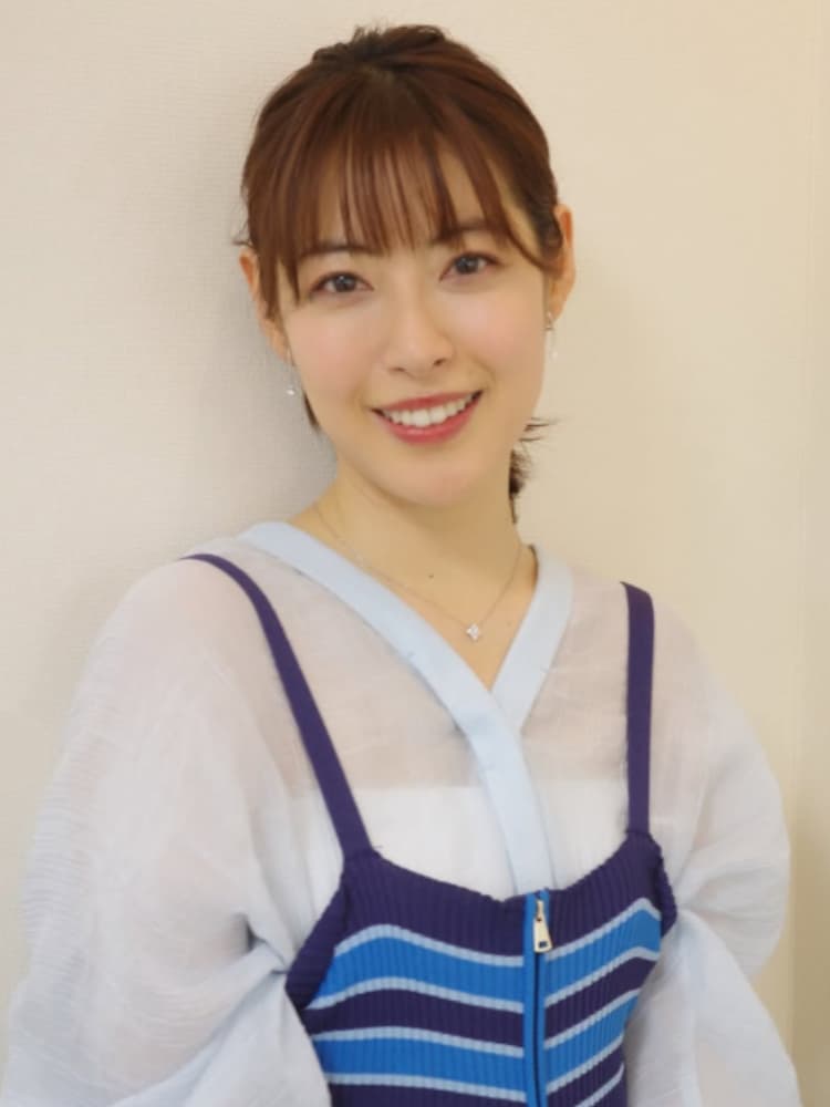 カメラを見て微笑む瀧本美織氏。白いシースルーのブラウスを着用。