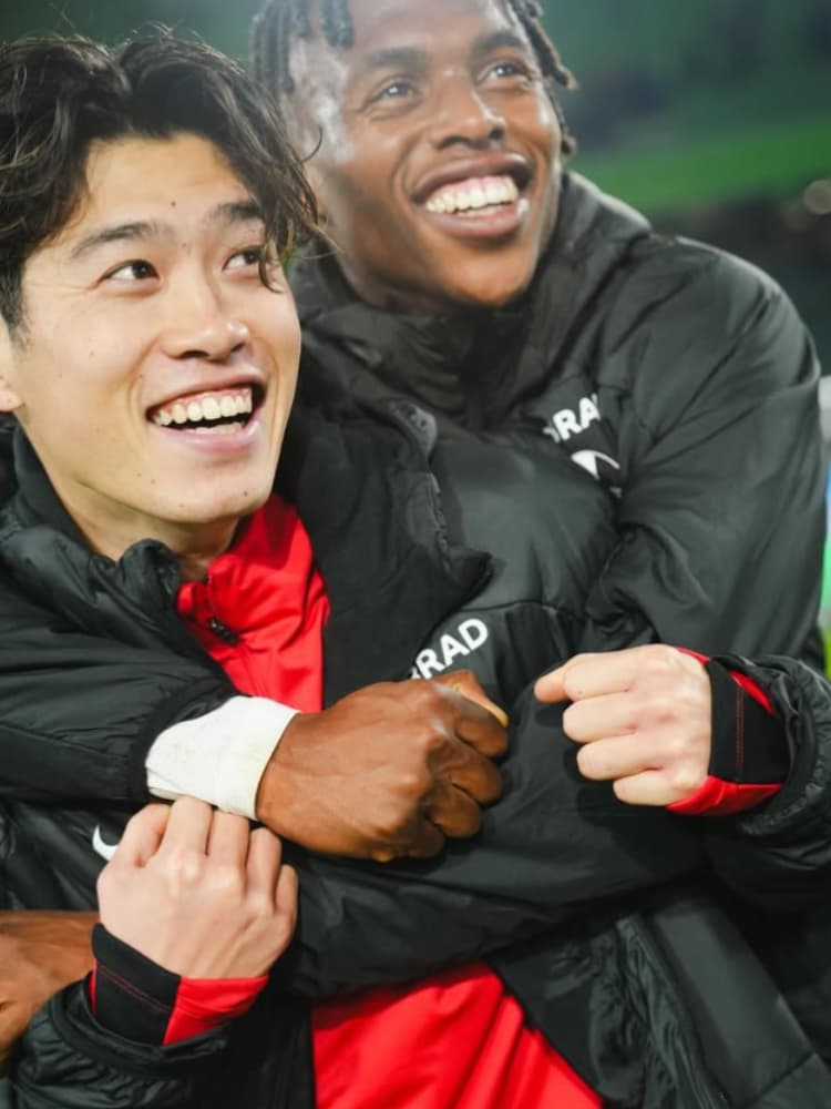 SCフライブルクのチームメイトと笑顔で抱き合い、喜びを分かち合う鈴木唯人選手。彼のシャイながらも明るい素顔が垣間見える瞬間。