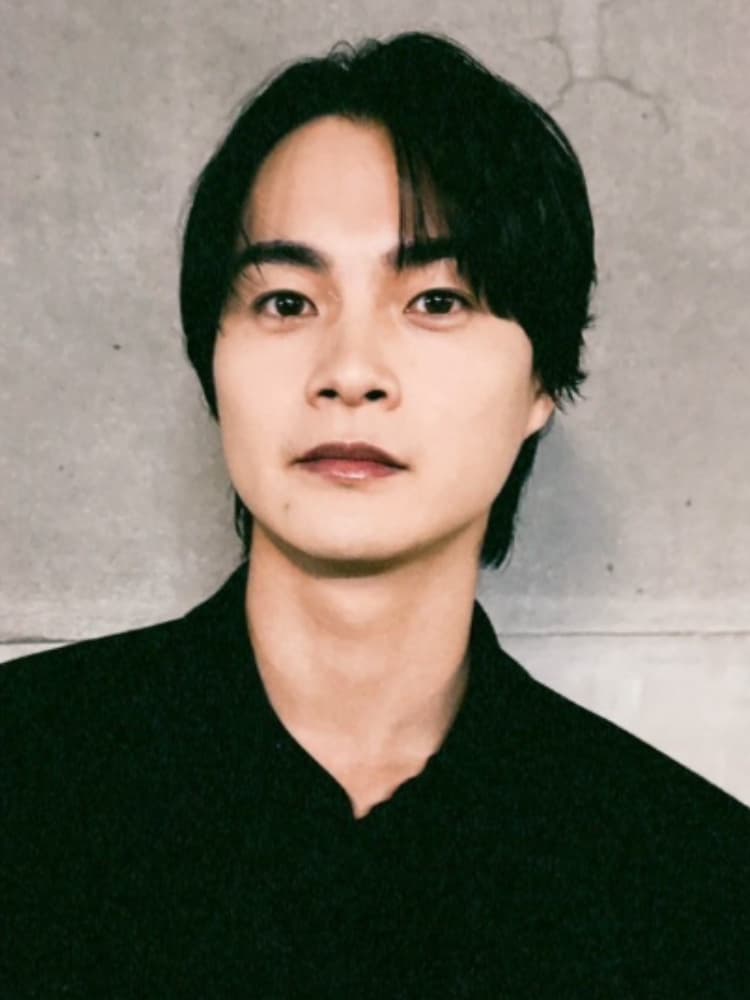 コンクリート壁の前で真剣な表情を浮かべる俳優の結木滉星氏。黒いシャツ姿のポートレート。