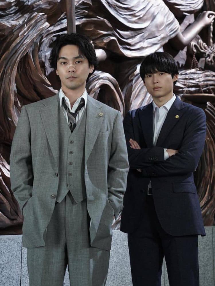 Netflixシリーズ『九条の大罪』より、ボサボサの髪と鼻ピアスが特徴的な弁護士・九条間人を演じる柳楽優弥と、スーツ姿で腕を組む烏丸真司役の松村北斗のツーショット。