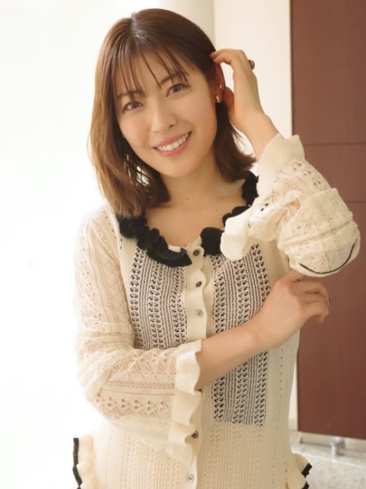 カメラを見て微笑む瀧本美織氏。白いカーディガンを着用。