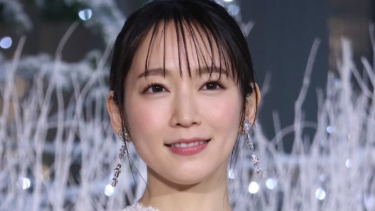 白いドレス姿で、冬のイルミネーションを背に微笑む吉岡里帆のポートレート写真。